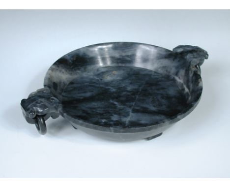 A 19th century black and white jade bowl, the exterior rim with a band of thunder scrolls, mask topped ring handles to each s