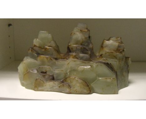 A grey green jade brush rest carved as a triple peaked massif, 20cm (8 in) wide  