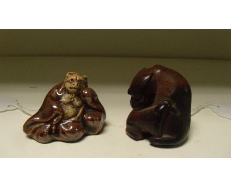 An 18th century style wooden netsuke of two monkeys together with a Bizen ceramic netsuke, the parent and child monkey seated