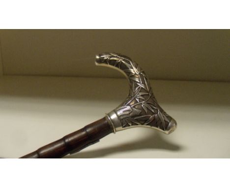 A lady's bamboo walking stick with silver handle by Wang Hing, the latter cast with a dragon on one side and bamboo on the ot