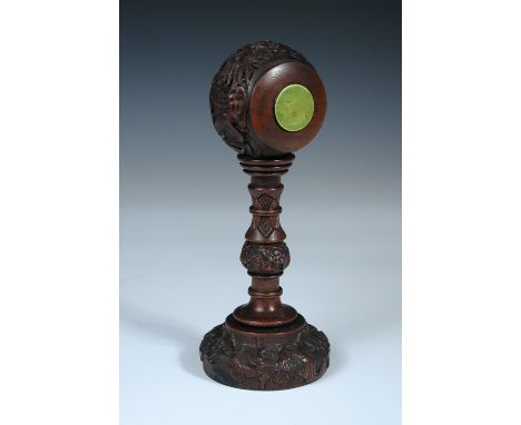 A late 19th/early 20th century carved wood hat stand, the bun shaped head inlaid on each flat side with green stained bone ro