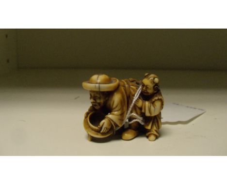 A 19th century ivory netsuke of a westerner and child, the bearded man bends over a garden pot while his child stands to his 