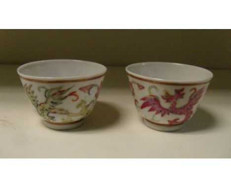 A pair of tea bowls, six character marks of Yongzheng, the exteriors painted with alternating dragons and flowers between gil