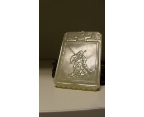 An off white jade pendant, the russet skin of rectangular shape carved to show a dragon and a sage, 5cm (2 in) high  