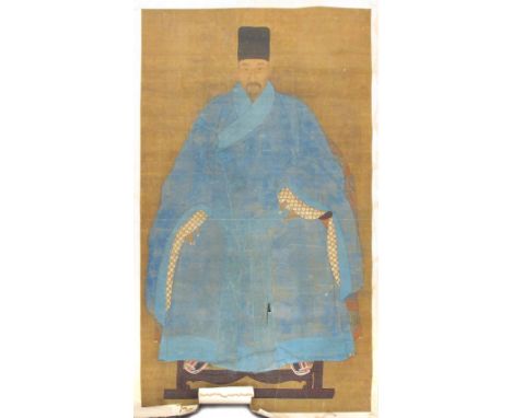 An 18th century portrait scroll, of a dignitary wearing a blue robe lined in material with white cherry blossoms on a brown g