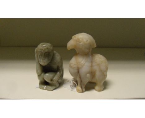 A brown streaked white jade beast and a jade monkey, the first carved with a horn and bulging eyes above its beak, 6.6cm (2.5