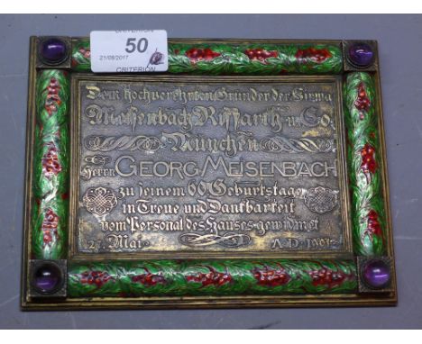 A brass German plaque decorated with green and red enamel and amethyst glass cabouchons  with reference to Georg Meisenbach