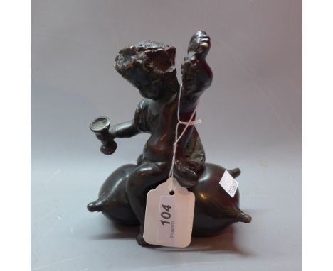 A bronze off a putti sitting on a pillow
