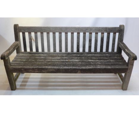 A weathered teak three seater garden bench.