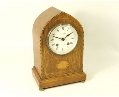 EDWARDIAN CLOCK. An Edwardian oak mantel clock with inlaid shell &amp; stringing. Height 28cm.