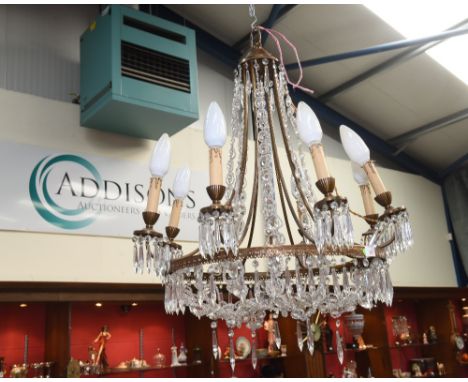 A gilt metal lustre drop eight light chandelier