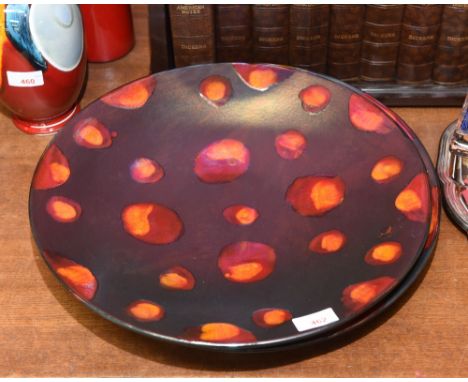 A pair of large Poole Pottery chargers, mid 20th Century decorated by Anita Harris with burnt orange glazed circles on a blac