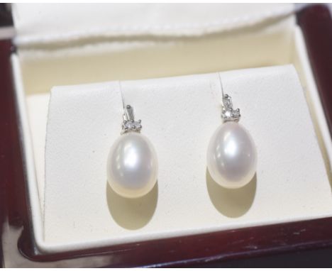 A pair of diamond and fresh water pearl drop earrings mounted in 9ct gold