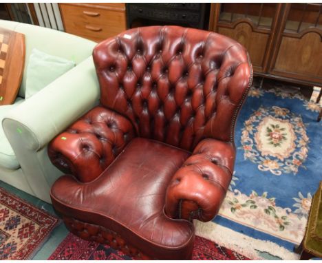 A red leather button backed armchair