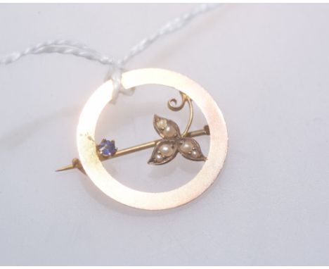 A 9ct gold circular seed pearl and single sapphire brooch