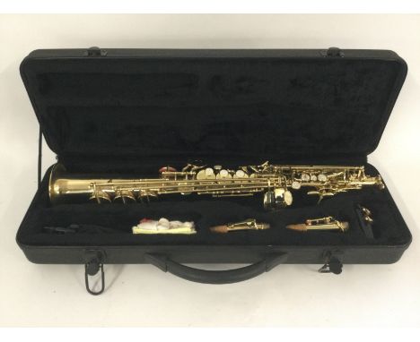 A cased Stagg soprano saxophone with accessories.