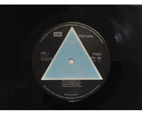A first UK pressing of 'Dark Side Of The Moon' by Pink Floyd with solid blue triangle centre label, both posters and stickers