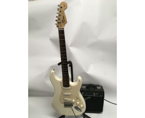 A Squier Stratocaster in aged White with hard case and a Squier SP10 amplifier