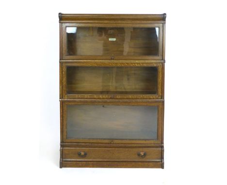 A Globe Wernicke oak three tier bookshelf on a drawer plinth base, applied label to one, h. 125 cm,  w. 87 cm CONDITION REPOR