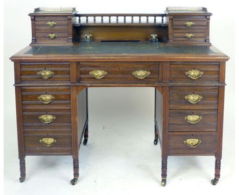 An Edwardian walnut and leather inlaid twin pedestal desk, the superstructure with four trinket drawers on a base with an arr