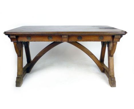 A Victorian Gothic oak centre table in the style of A.W.N. Pugin, the canted rectangular top frieze with flower head carving,