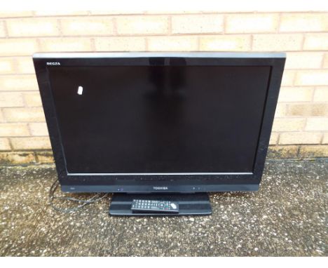 A 32 inches Toshiba LCD TV model #32AV635D with remote control.