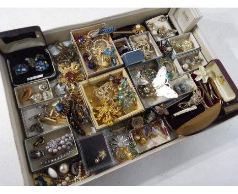 A large quantity of vintage costume jewellery to include brooches, paired earrings, necklaces, tie clips and similar