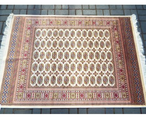 A Bokhara carpet on a beige ground measuring 140 cm x 190 cm. Est £70 - £90 This lot MUST be paid for and collected, or deliv