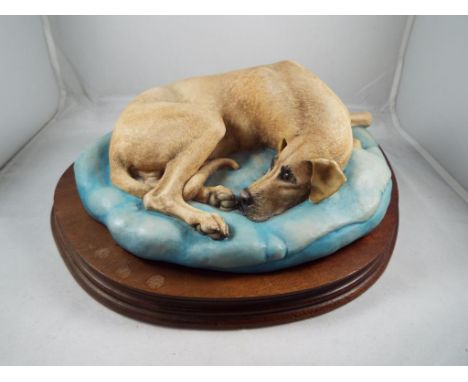 A Border Fine Arts model depicting a recumbent Great Dane on a wooden plinth by E. Waugh. Estimate £20 - £40