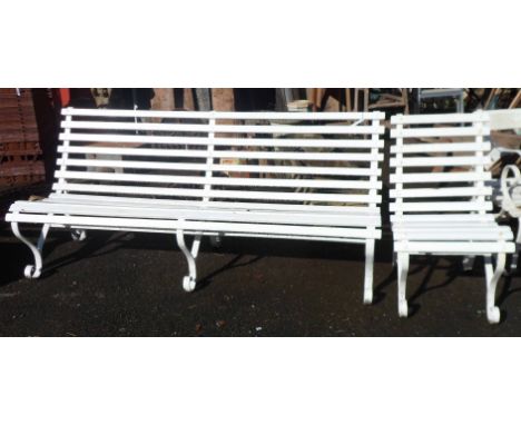 An antique wrought iron three seater garden bench with wooden slat seat and later white painted finish - sold with a matching
