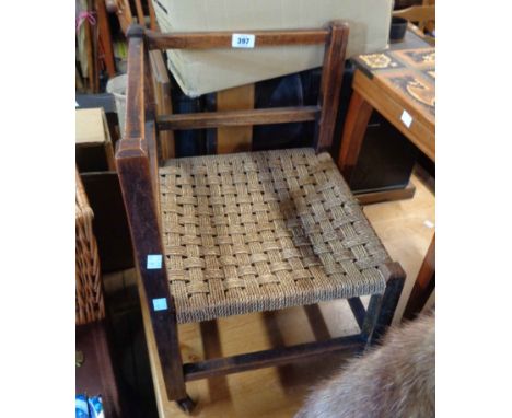 A vintage stained oak framed corner chair with woven seagrass seat panel