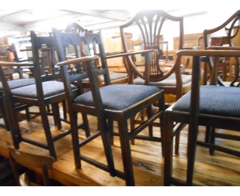 A set of four dark Ercol 'Gothic' elbow chairs with upholstered drop-in seats, set on moulded supports