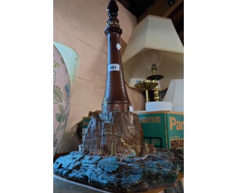 An old turned carved wood table lamp in the form of a lighthouse with metal detailing, set on a later plastic base