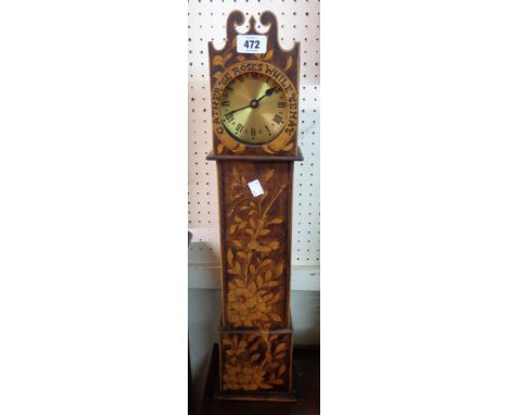 A miniature longcase clock with extensive pen work floral decoration and legend to dial surround - with battery movement