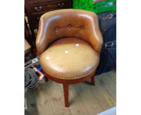 A late 20th Century stained wood framed swivel chair with studded button back leather upholstery