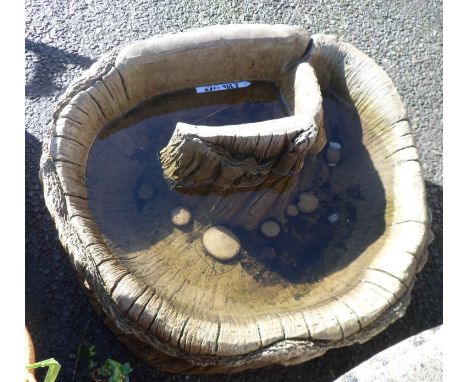 A concrete garden pond of hollowed tree trunk form