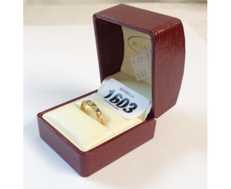 A 750 (18ct.) gold ring, set with four small sapphires interspersed with three small diamonds - boxed