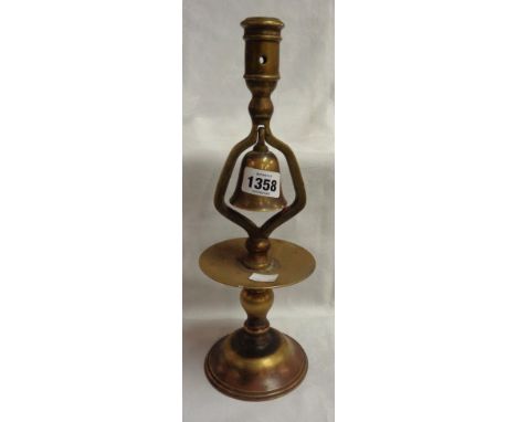 An old cast brass tavern candlestick with central bell and drip tray under