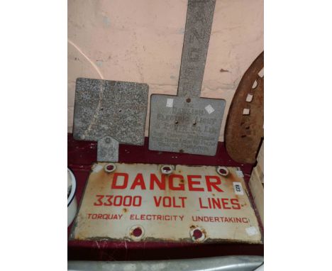 An old enamel electricity warning sign with Danger 33,000 Volt lines Torquay Electricity Undertaking in red letters on white 
