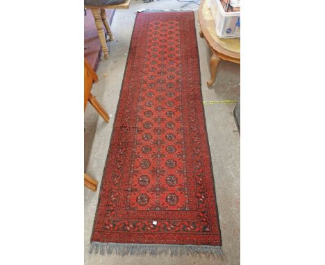 A handmade Middle Eastern runner with repeat medallion decoration and geometric border on red ground - 2.8m long
