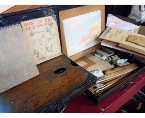 A vintage black japanned paint box with slide-out wooden palette and containing a small quantity of artist's equipment includ