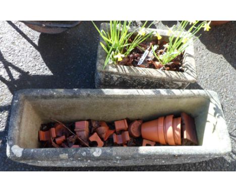 A large concrete oblong planter, a smaller similar planted with daffodils and a selection of small terracotta flowerpots, etc