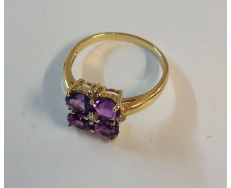 A 375 gold ring, set with four amethysts interspersed with tiny diamonds - boxed