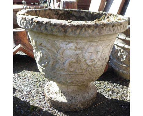 A concrete garden planter of pedestal form with scrolling foliate decoration