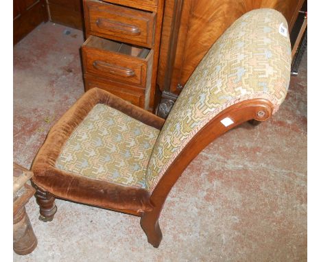 A Victorian mahogany framed scroll back nursing chair with tapestry upholstery, set on turned front legs with brass caps and 