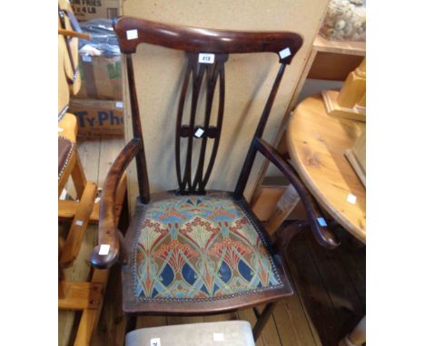 An early 20th Century stained mahogany framed elbow chair with pierced splat back and studded upholstered seat panel, set on 