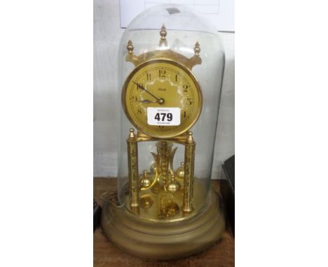 A vintage Kundo brass anniversary clock with ball pendulum under glass dome - with key