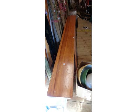 A 2.44m varnished pine form bench, set on braced standard ends