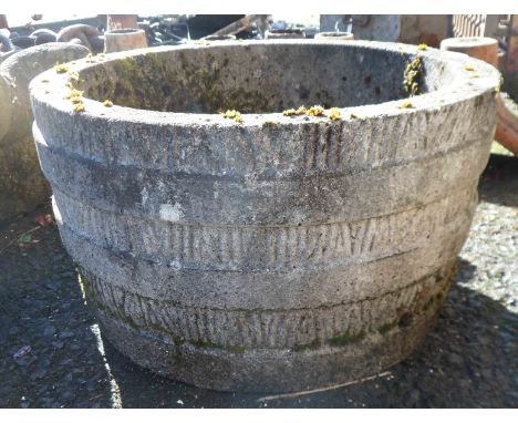 A concrete garden planter in the form of a half barrel
