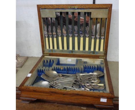 A vintage oak canteen containing a part six place setting of silver plated cutlery and other loose cutlery